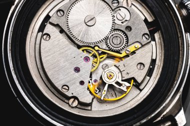 Eski bir kol saatinin dişli mekanizmasına yakın çekim