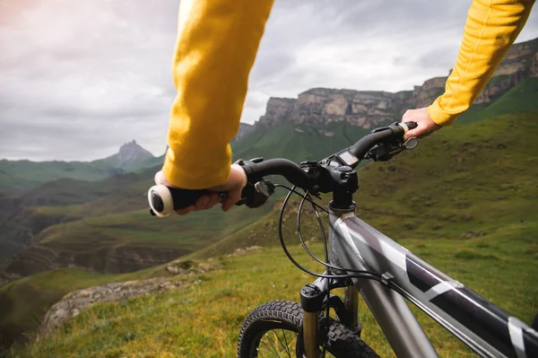 Primer plano de las manos femeninas sosteniendo el manillar de una bicicleta de montaña en el verano en las montañas —  Fotos de Stock