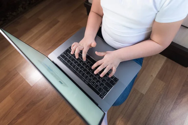 Pohled shora holčička se zabývá na notebooku, zatímco sedí na podlaze — Stock fotografie