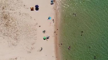 Orta Asya 'nın gökyüzü manzarası, dinlenen turistler ve plaj şemsiyeleri. Deniz kenarında turizm ve eğlence için arka plan