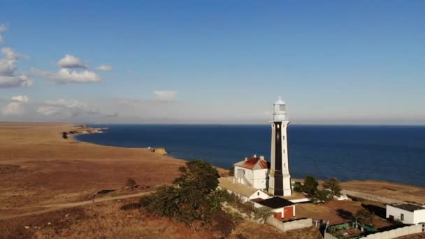 Вид з повітря на прибережний морський маяк стоїть на узбережжі або в океані. Історичні будівлі спеціального призначення — стокове відео