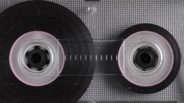 Close-up A tape recorder is playing an audio cassette. Close-up. A vintage audio cassette spins on a blank label tape used to record sound in a retro cassette player. Recording of conversations. — Stock Video