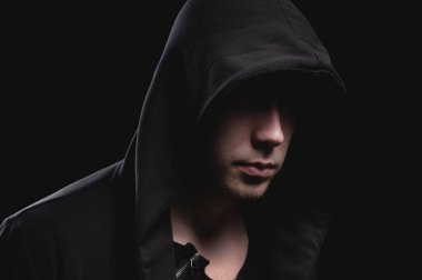 Siyah arka planda koyu kapüşonlu cesur bir adamın portresini yakından çek. Sırların gizliliği kavramı ve hükümetten saklanan insanlar. Hackerlar ve hırsızlar. Alçak tuş