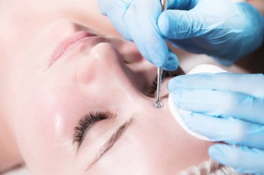 Güzellik salonunda mekanik yüz temizleme prosedürü. Kafkas genç modeli kozmetik yüz bakımı ve bir güzellik uzmanından prosedür alıyor. Spa, kozmetoloji ve sağlık rahatlama kavramı.
