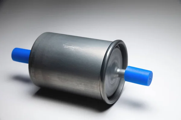 Новый топливный фильтр для двигателя внутреннего сгорания бензина с голубыми колпачками на сером фоне. Новые запасные части — стоковое фото