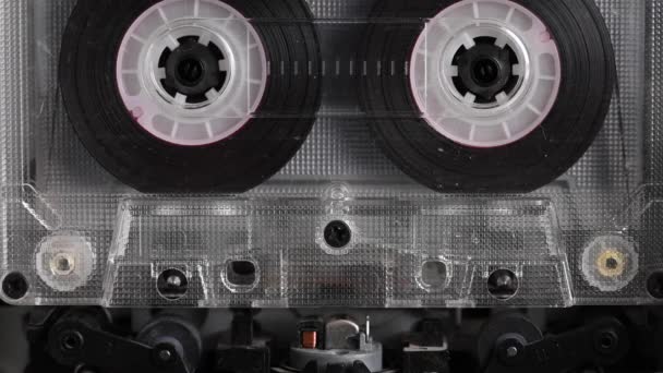 Großaufnahme Ein Tonbandgerät spielt eine Audiokassette ab. Nahaufnahme. Eine alte Audiokassette dreht sich auf einem leeren Etikettenband, das verwendet wird, um Ton in einem Retro-Kassettenspieler aufzunehmen. Aufzeichnung von Gesprächen. — Stockvideo