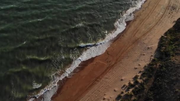 Luchtfoto van de vlucht over steile rotsachtige kustlijn. De zee tijdens een storm met golven en schuim — Stockvideo
