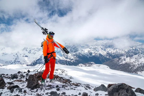 Jovem desportista esquiador em máscara com esquis no fundo das montanhas do Cáucaso — Fotografia de Stock