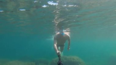 Harika bir yüzücü olan atletik beyaz bir erkek tarafından çekilen sualtı selfie 'si. Deniz ya da okyanus tarafından serbest dalış ve rahatlama kavramı