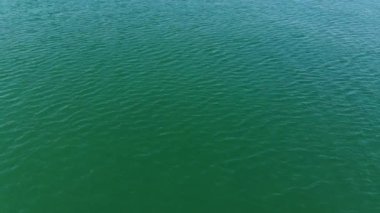 Turkuaz deniz suyunun yüksek irtifa mavi gök mavisi dokusundan havadan aşağıya doğru görüntüsü. Su yüzeyinin manzarası. Su yüzeyi arkaplanı.