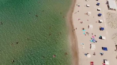 Orta Asya 'nın gökyüzü manzarası, dinlenen turistler ve plaj şemsiyeleri. Deniz kenarında turizm ve eğlence için arka plan