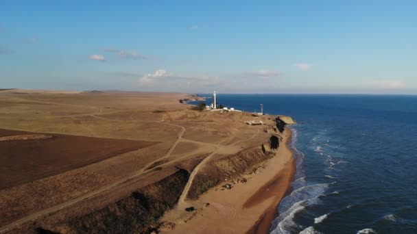 Veduta aerea di un faro sconosciuto con bordi in bianco e nero sul promontorio delle penisole. Piano piano. pellicola di grano — Video Stock