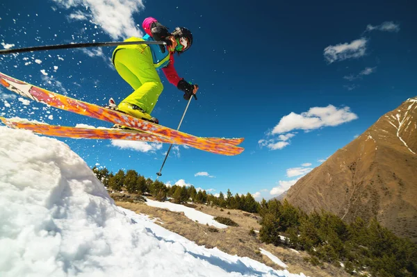 Jovem esportista mulher pulando de um trampolim de neve no alto das montanhas — Fotografia de Stock