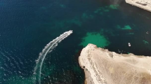 Körfezdeki küçük bir sürat teknesinin havadan görüntüsü. Açık deniz taşımacılığı üst görüntü. Turkuaz suyun tropikal körfezinin inanılmaz manzarası. — Stok video