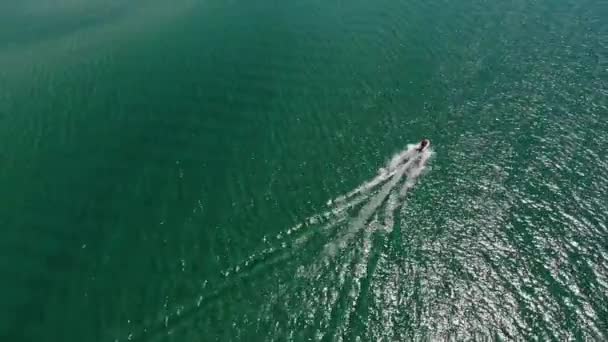 Letecký pohled na malý rychlostní člun v zálivu. Pohled shora na lehkou vodu. Úžasný výhled na tropický záliv tyrkysové vody — Stock video