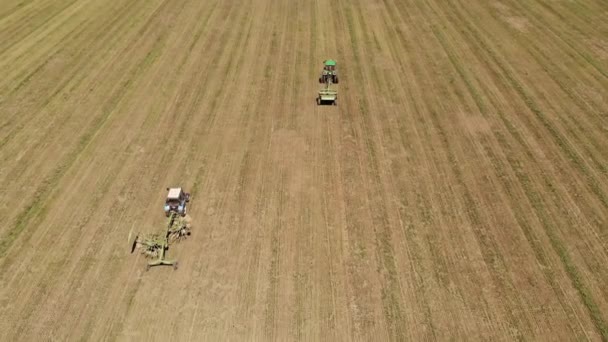 Letecký pohled na traktor se sekačkou seká trávu na prázdném poli. Příprava a údržba terénu po celý rok — Stock video