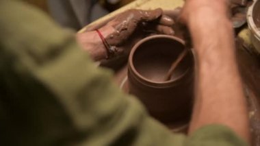 Erkek ellerinin çömlekçi çarkında kil kase yaptığı yakın plan. El işi ve kilden yapılmış özel çay takımları.