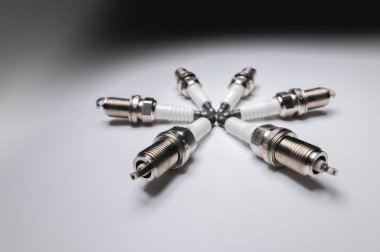 Gri gradyan arka planda altı silindirli araba motoru için yeni buji kitleri