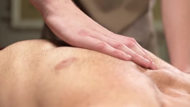 Επαγγελματικό μασάζ των θωρακικών μυών για έναν άνδρα σε έναν αθλητή σε ένα ινστιτούτο μασάζ — Αρχείο Βίντεο