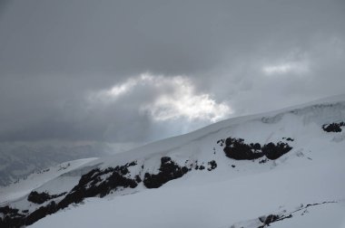 Kafkas dağları ve buzullar akşam bulutlu havalarda. Sakin, renkli bir manzara değil.