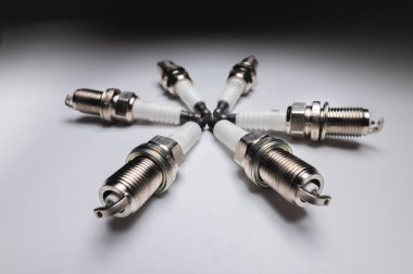 Gri gradyan arka planda altı silindirli araba motoru için yeni buji kitleri