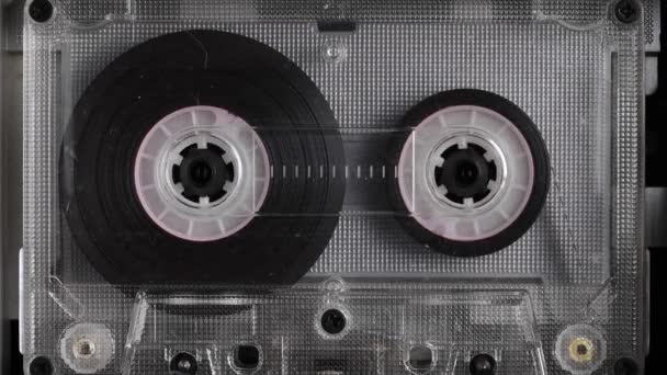 Close-up A tape recorder is playing an audio cassette. Close-up. A vintage audio cassette spins on a blank label tape used to record sound in a retro cassette player. Recording of conversations. — Stock Video
