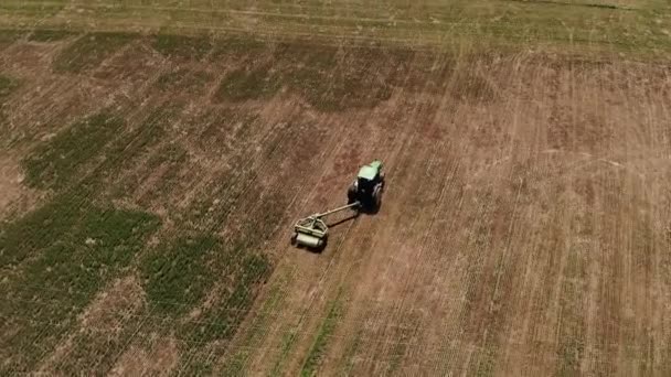 Vista aérea de um trator com um cortador de relva corta a grama em um campo vazio. Preparação e manutenção de campo durante todo o ano — Vídeo de Stock