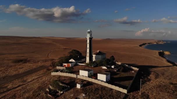 Veduta aerea di un faro sconosciuto con bordi in bianco e nero sul promontorio delle penisole. Piano piano. pellicola di grano — Video Stock