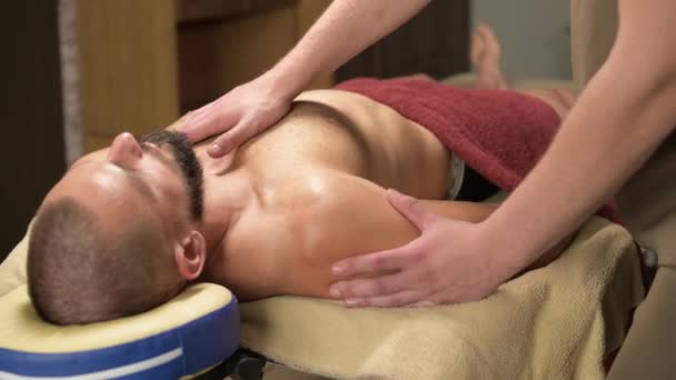 Masaje profesional de los músculos pectorales para un hombre a un atleta en una sala de masajes — Vídeo de stock