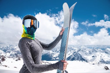 İnce Müslüman bir sporcunun portresi kapalı bir yüzle ellerinde kayaklarla Kafkasya 'nın yüksek dağlarının arka planına yaslanmış.