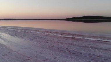 Havadan aşağıya doğru eğilmiş Pembe Tuz Gölü alçak anahtarı. Sinematik film tahılları. Akşam çekimi.