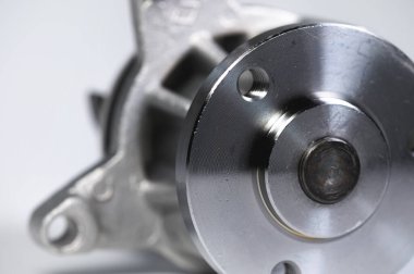 Gri arka planda yeni bir içten yanmalı motorun soğutucu su pompasının yakın çekimi. Karşıtlık ışığı