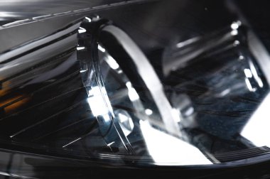 Yumuşak odaklı bir yolcu arabası için yeni bir far yakın plan. Otomatik ışıklandırma teması arkaplanı