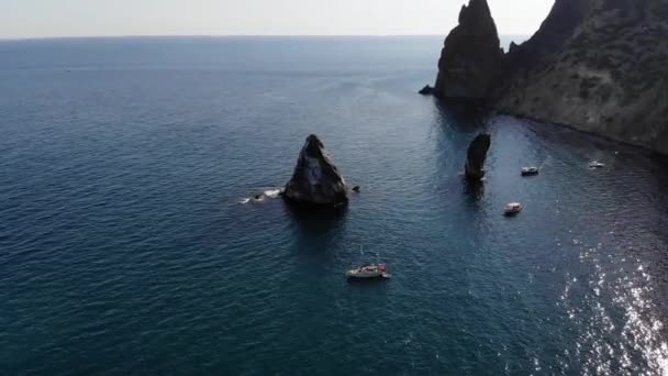 Felülnézetből. Légi felvétel a 4K drónról. Kristálytiszta tenger óceán turistahajókkal és kis hajókkal. Köpeny magas sziklákkal — Stock videók