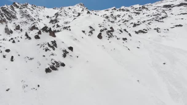Luchtfoto van besneeuwde steile hellingen. Smalle couloirs voor extreme freeride en backcountry skiën hoog in de bergen — Stockvideo