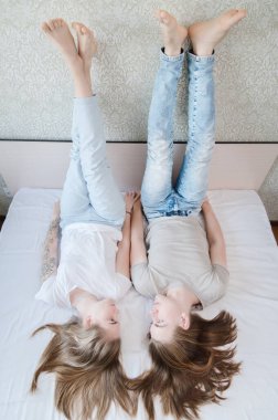 Genç, çekici, heteroseksüel çift, kadın ve erkek, gündelik giysiler içinde yatak odasında uzanıyorlar..