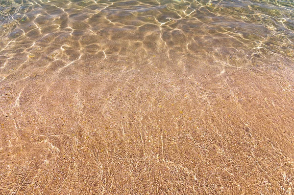 Napsütés kék vízen a tengeren és homokos napon egy napsütéses napon — Stock Fotó
