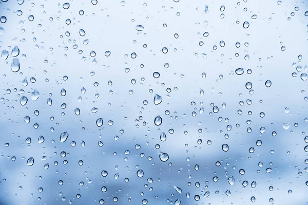 Капли дождя на стекле, крупный план, фон, холодно-голубые цвета — стоковое фото