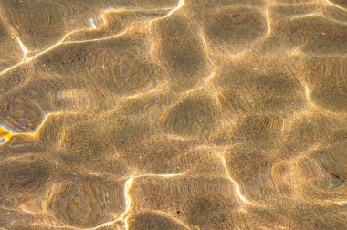 Yakın plan. Üst görünüm, gün ışığından parlayan şeffaf su yüzeyini sakinleştir