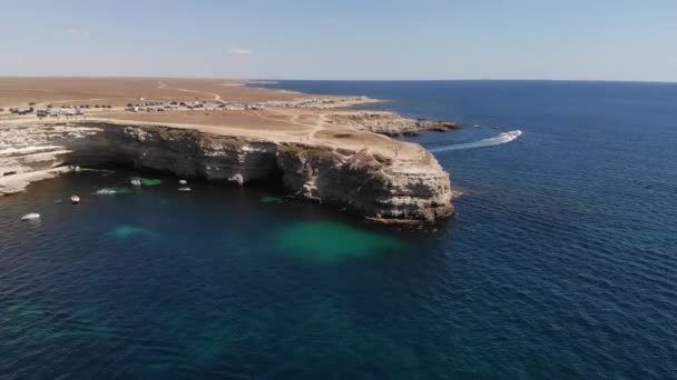 Felülnézetből. Légi felvétel a 4K drónról. Kristálytiszta tenger óceán turistahajókkal és kis hajókkal. Köpeny magas sziklákkal — Stock videók