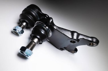 Gri arka planda bir yolcu vagonunun ön süspansiyonunda iki topun birleşimi. Servis ve yeni parçalar