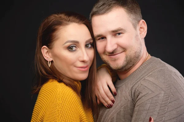 Caucásico casado pareja hombre y mujer abrazando y besando los ojos cerrados. Estilo casual y ropa brillante de un retrato de estudio de pareja de 30 años ordinario — Foto de Stock