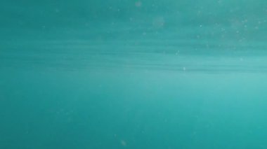 Dalgaların yüzeyinin yansımasında suyun altından deniz arka planının soyut görüntüsü ve güneş ışınları parlıyor ve parlıyor.