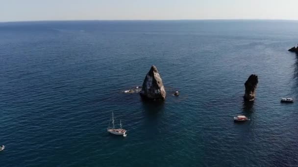 Vista aérea de barcos turísticos na baía do mar ao lado de rochas individuais e alta costa rochosa. Férias mediterrânicas de luxo — Vídeo de Stock