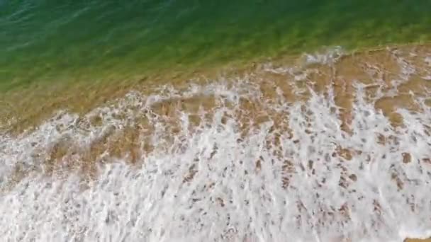 空中俯瞰大海的蓝色波浪在海滩上冲撞.海浪和美丽的沙滩鸟瞰从无人驾驶飞机上拍摄. — 图库视频影像