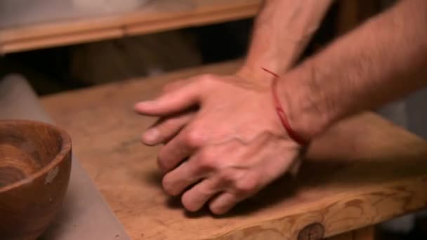 Close-up of a man potter kneading clay beats it for installation on a potters wheel — Stock Video