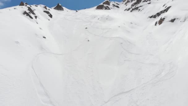 Luftudsigt atlet skiløber freerider står på sidelinjen højt oppe i bjergene forbereder sig på at stige ned. Skitour og freeride på de uforberedte skråninger i det nordlige Kaukasus – Stock-video