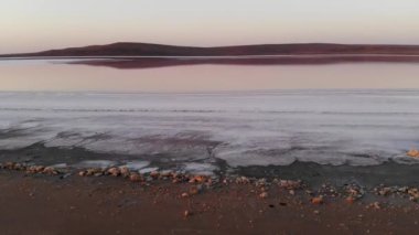 Havadan aşağıya doğru eğilmiş Pembe Tuz Gölü alçak anahtarı. Sinematik film tahılları. Akşam çekimi.
