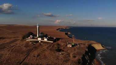 Yarımadada siyah beyaz kenarlı, bilinmeyen bir deniz fenerinin havadan görünüşü. Alçakgönüllülük. film tahılı