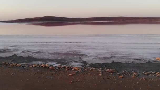 Letecký pohled Nakloněný dolů Pink Salt Lake nízký klíč. Filmová zrna. Večerní snímek — Stock video